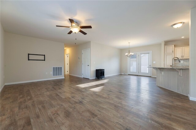 109 Chickadee Ln Unit A24, South Kingstown, RI 02879 - unfurnished living room with a wood stove, a ceiling fan, dark wood-type flooring, and a chandelier