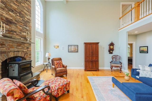 51 Reservoir Rd, Cumberland, RI 02864 - living room featuring a towering ceiling, light wood-type flooring, baseboards, and a wood stove