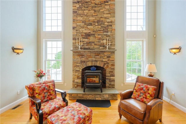 51 Reservoir Rd, Cumberland, RI 02864 - sitting room featuring a wood stove, wood finished floors, a towering ceiling, and baseboards