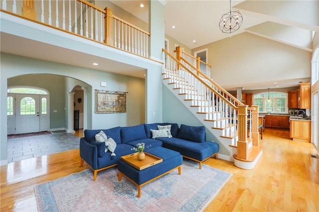 51 Reservoir Rd, Cumberland, RI 02864 - living room with arched walkways, high vaulted ceiling, stairs, plenty of natural light, and light wood-type flooring