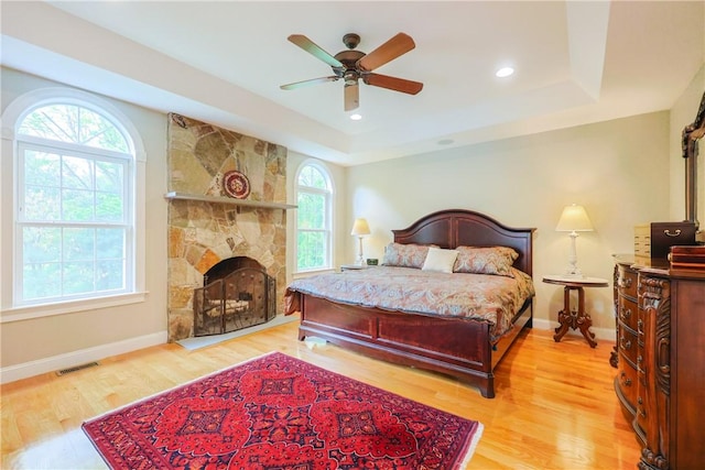 51 Reservoir Rd, Cumberland, RI 02864 - bedroom featuring light wood finished floors, a raised ceiling, baseboards, a fireplace, and a ceiling fan