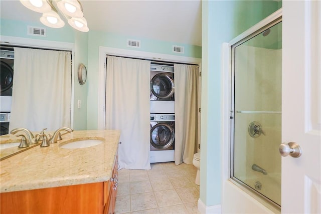 51 Reservoir Rd, Cumberland, RI 02864 - bathroom with estacked washer and dryer, vanity, toilet, tile patterned flooring, and enclosed tub / shower combo