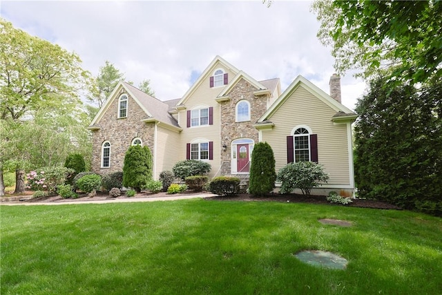 51 Reservoir Rd, Cumberland, RI 02864 - view of front of house with stone siding, a chimney, and a front lawn