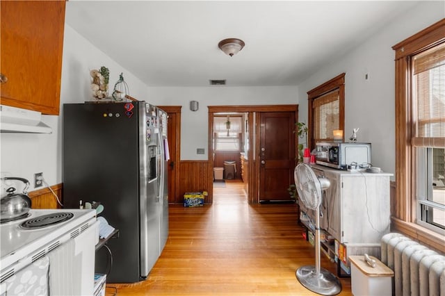 93 Pleasant St, Cranston, RI 02910 - kitchen featuring ventilation hood, radiator, light wood-style flooring, stainless steel fridge with ice dispenser, and wainscoting
