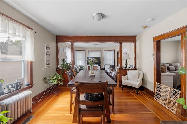 93 Pleasant St, Cranston, RI 02910 - dining area featuring radiator, ornate columns, healthy amount of natural light, and light wood-type flooring