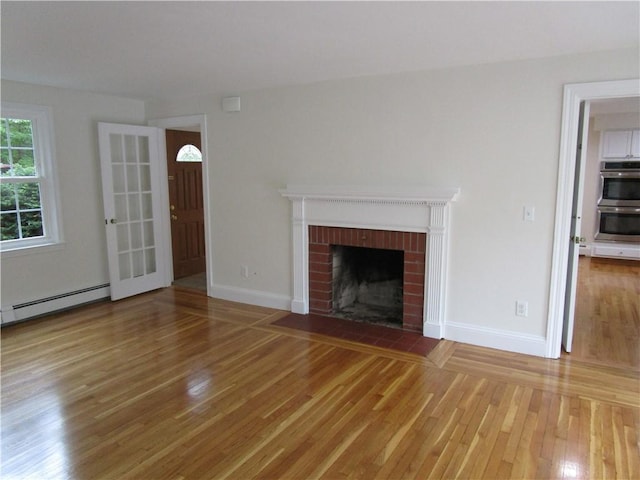 524 Middle Rd, East Greenwich, RI 02818 - unfurnished living room with light wood finished floors, a baseboard radiator, a fireplace, and baseboards