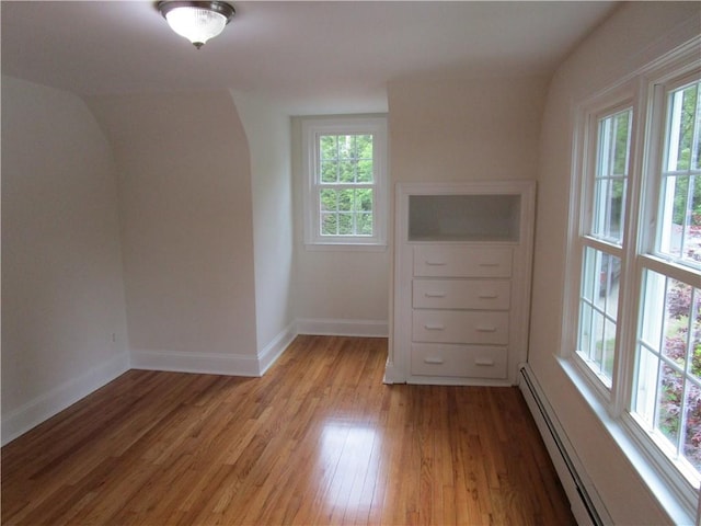 524 Middle Rd, East Greenwich, RI 02818 - additional living space with light wood-style flooring, baseboard heating, baseboards, and arched walkways