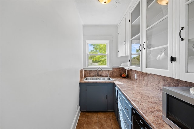 39 Sampson Ave, North Providence, RI 02911 - kitchen featuring stainless steel microwave, a sink, blue cabinets, dark tile patterned floors, and glass insert cabinets