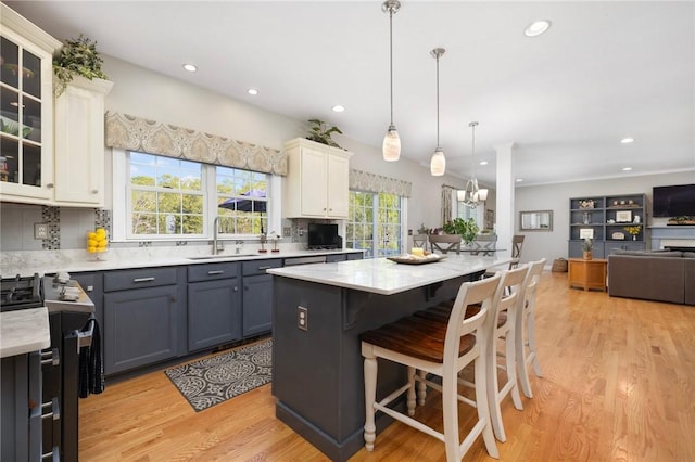 114 Teaberry Dr, Tiverton, RI 02878 - kitchen featuring gas range oven, a sink, light wood-style floors, glass insert cabinets, and recessed lighting