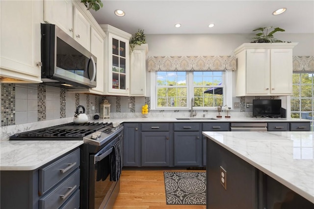 114 Teaberry Dr, Tiverton, RI 02878 - kitchen with stainless steel appliances, a sink, white cabinetry, light stone counters, and decorative backsplash