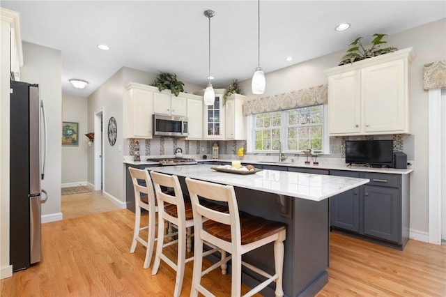 114 Teaberry Dr, Tiverton, RI 02878 - kitchen with appliances with stainless steel finishes, a sink, a breakfast bar, white cabinets, and recessed lighting