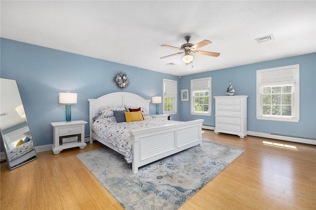 114 Teaberry Dr, Tiverton, RI 02878 - bedroom with wood finished floors, baseboards, ceiling fan, and baseboard heating