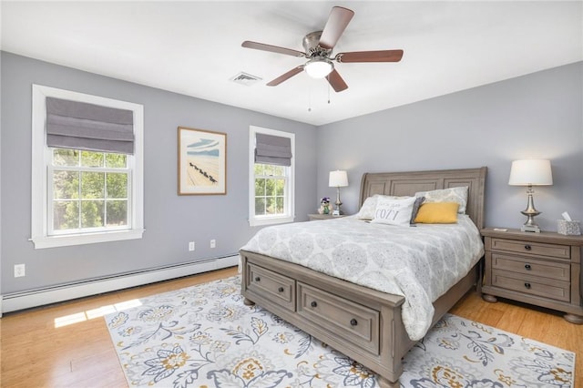 114 Teaberry Dr, Tiverton, RI 02878 - bedroom featuring a baseboard radiator, light wood-style flooring, and ceiling fan