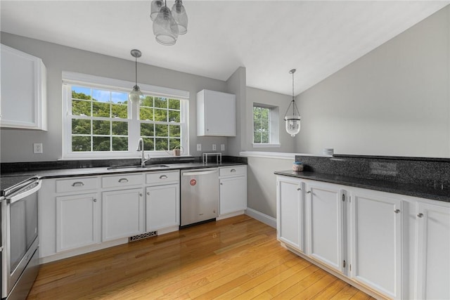 299 S Christopher Ave, Tiverton, RI 02878 - kitchen featuring stainless steel appliances, a sink, dark countertops, light wood-style flooring, and white cabinetry