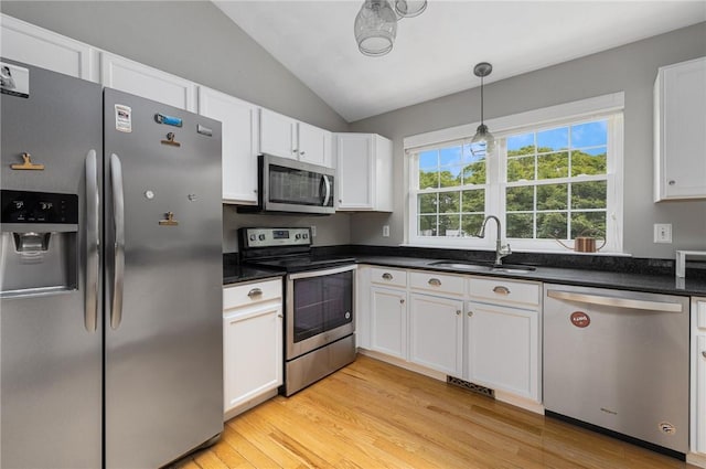299 S Christopher Ave, Tiverton, RI 02878 - kitchen featuring appliances with stainless steel finishes, a sink, light wood-style flooring, vaulted ceiling, and white cabinets