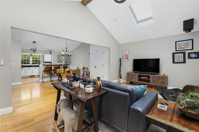 299 S Christopher Ave, Tiverton, RI 02878 - living room with a chandelier, light wood-type flooring, a skylight, baseboards, and high vaulted ceiling