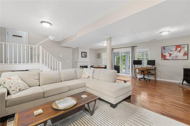 299 S Christopher Ave, Tiverton, RI 02878 - living room with wood finished floors, stairs, baseboards, a fireplace, and an office area