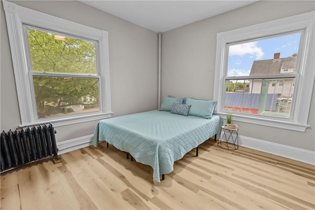 1413 Broad St, Providence, RI 02905 - bedroom with radiator heating unit, baseboards, and wood finished floors