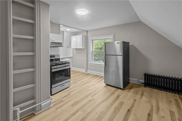 1413 Broad St, Providence, RI 02905 - kitchen featuring appliances with stainless steel finishes, radiator heating unit, light wood finished floors, white cabinets, and vaulted ceiling