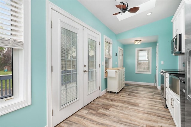 130 Alice Ave, Woonsocket, RI 02895 - entryway featuring french doors, a skylight, vaulted ceiling, light wood-style floors, and plenty of natural light