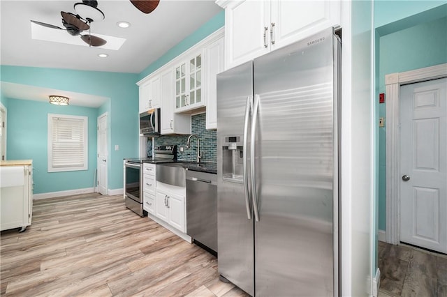 130 Alice Ave, Woonsocket, RI 02895 - kitchen featuring appliances with stainless steel finishes, a ceiling fan, white cabinetry, a sink, and light wood finished floors