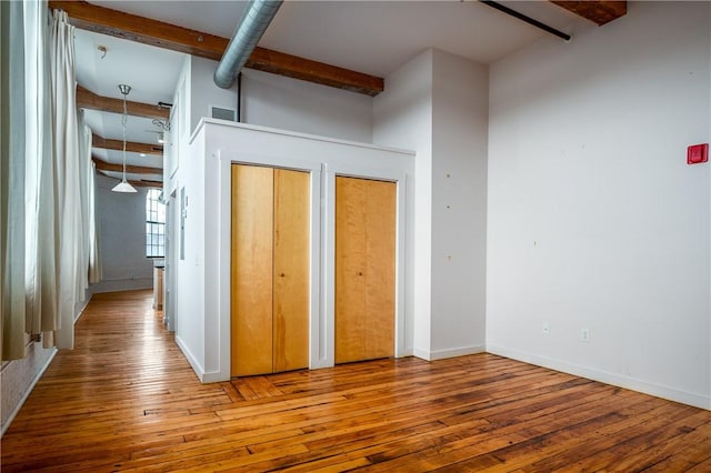 28 Bayley St Unit 304, Pawtucket, RI 02860 - unfurnished bedroom featuring beamed ceiling, hardwood / wood-style floors, two closets, and baseboards