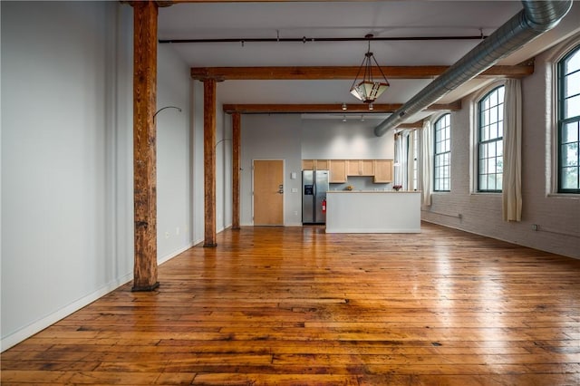 28 Bayley St Unit 304, Pawtucket, RI 02860 - unfurnished living room featuring track lighting, wood-type flooring, beamed ceiling, and healthy amount of natural light