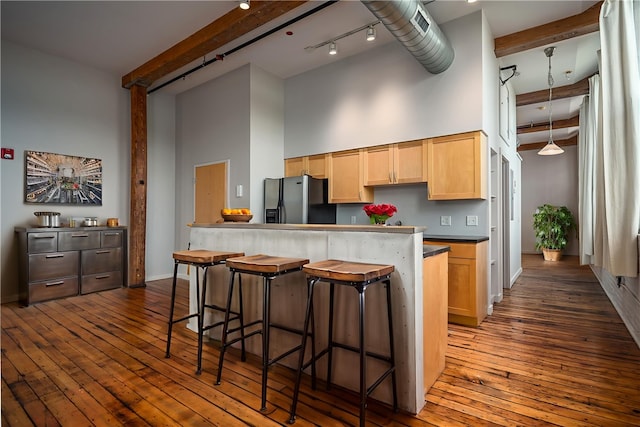 28 Bayley St Unit 304, Pawtucket, RI 02860 - kitchen featuring stainless steel refrigerator with ice dispenser, beam ceiling, a towering ceiling, a breakfast bar area, and dark wood-style flooring