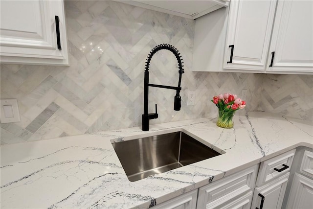 75 Pelham St Unit A, Newport, RI 02840 - kitchen view of a sink, decorative backsplash, white cabinetry, and light stone counters