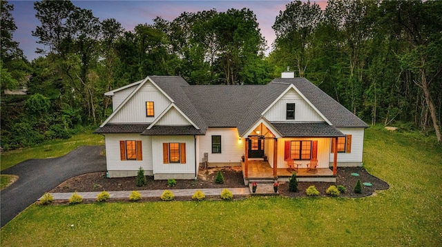 1332 S Rd, South Kingstown, RI 02879 - modern farmhouse featuring covered porch, a front lawn, a shingled roof, and asphalt driveway