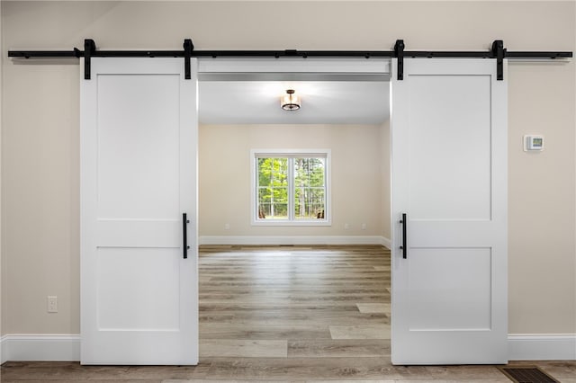 1332 S Rd, South Kingstown, RI 02879 - hall with a barn door, light wood-style flooring, and baseboards