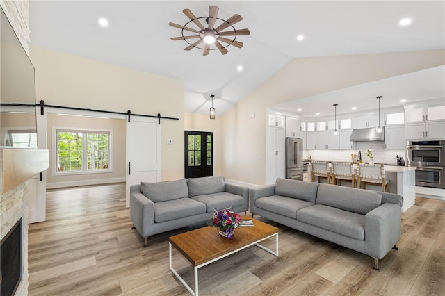 1332 S Rd, South Kingstown, RI 02879 - living room with a barn door, recessed lighting, light wood-style flooring, a ceiling fan, and high vaulted ceiling