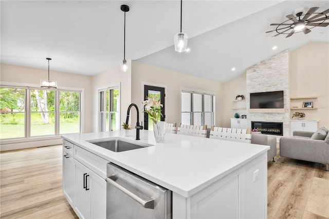 1332 S Rd, South Kingstown, RI 02879 - kitchen with stainless steel dishwasher, a sink, lofted ceiling, light wood-type flooring, and a stone fireplace
