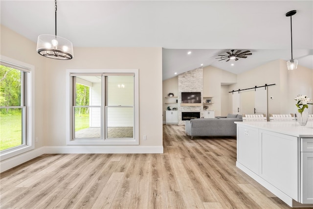 1332 S Rd, South Kingstown, RI 02879 - kitchen with vaulted ceiling, a barn door, light wood-style floors, a chandelier, and decorative light fixtures