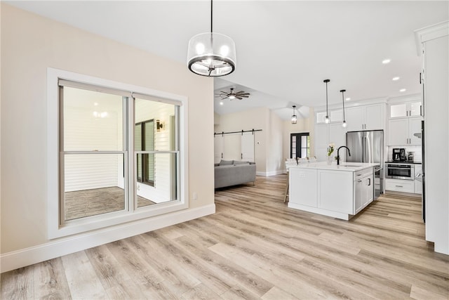 1332 S Rd, South Kingstown, RI 02879 - kitchen featuring open floor plan, a sink, baseboards, light countertops, and white cabinetry