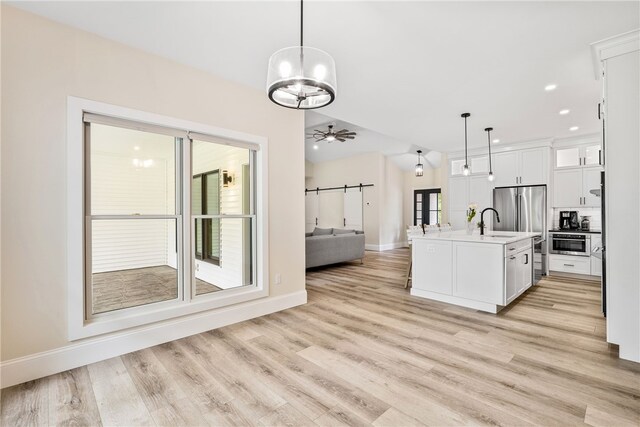 1332 S Rd, South Kingstown, RI 02879 - kitchen featuring open floor plan, a sink, baseboards, light countertops, and white cabinetry