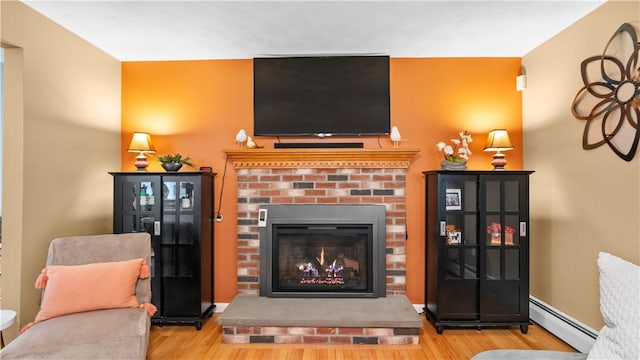 605 Gardner Rd, Exeter, RI 02822 - living area featuring baseboard heating, a brick fireplace, and wood finished floors