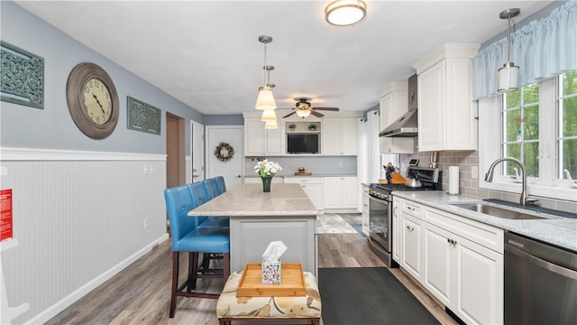 605 Gardner Rd, Exeter, RI 02822 - kitchen featuring stainless steel appliances, a sink, under cabinet range hood, wood finished floors, and white cabinetry