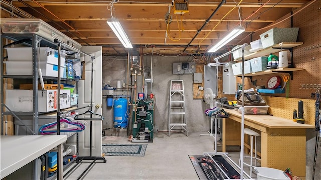 605 Gardner Rd, Exeter, RI 02822 - unfinished basement featuring a workshop area, a water pressure tank, and a heating unit