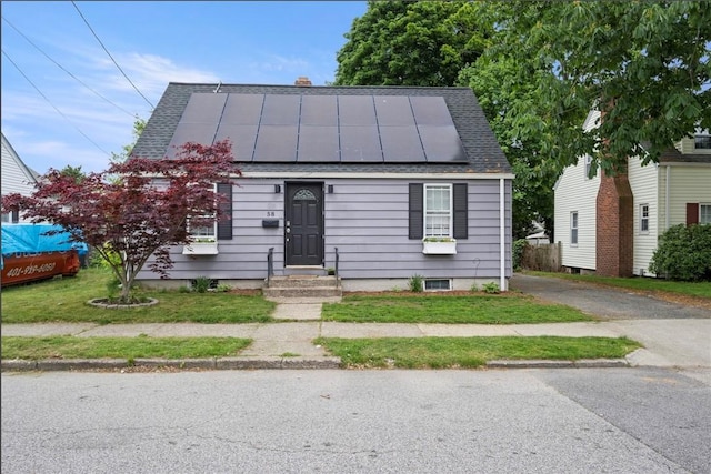 58 Edgemere Rd, Pawtucket, RI 02861 - view of front facade featuring solar panels, a chimney, a standing seam roof, and roof with shingles