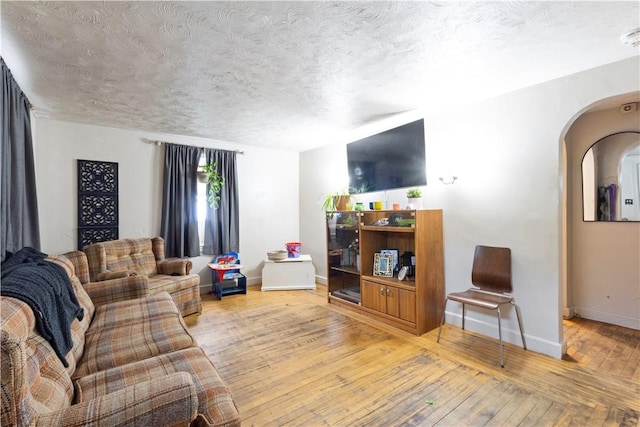 58 Edgemere Rd, Pawtucket, RI 02861 - living area with baseboards, a textured ceiling, arched walkways, and light wood finished floors