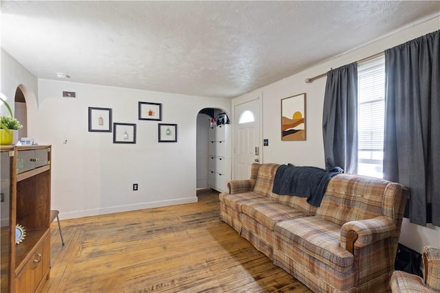 58 Edgemere Rd, Pawtucket, RI 02861 - living room with arched walkways, light wood-style floors, and baseboards
