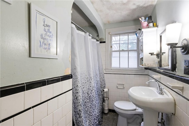 58 Edgemere Rd, Pawtucket, RI 02861 - bathroom with tile walls, toilet, a shower with shower curtain, wainscoting, and a textured ceiling