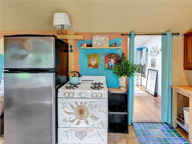219 Nanaquaket Rd, Tiverton, RI 02878 - kitchen featuring freestanding refrigerator, white gas range oven, and brown cabinets