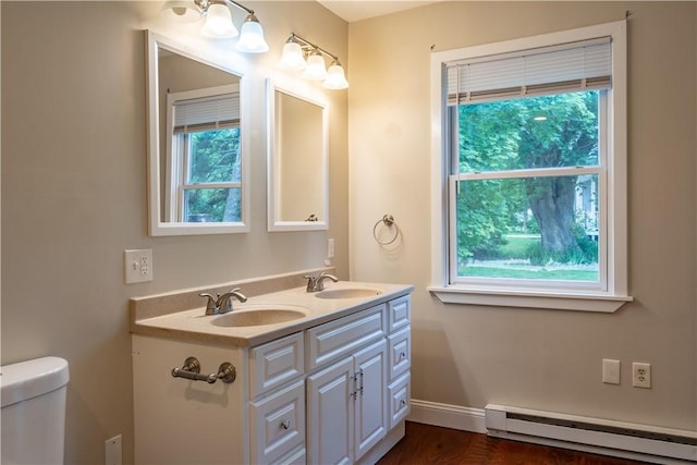 18 Railroad Ave, South Kingstown, RI 02892 - bathroom with a baseboard heating unit, double vanity, toilet, and baseboards
