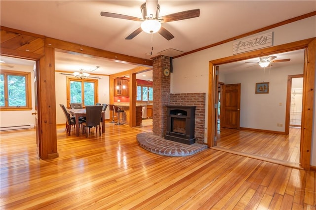 18 Railroad Ave, South Kingstown, RI 02892 - living area with light wood-style floors, a ceiling fan, a brick fireplace, a baseboard heating unit, and a chandelier