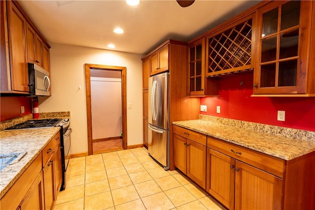 18 Railroad Ave, South Kingstown, RI 02892 - kitchen featuring appliances with stainless steel finishes, brown cabinetry, recessed lighting, light tile patterned floors, and light stone countertops