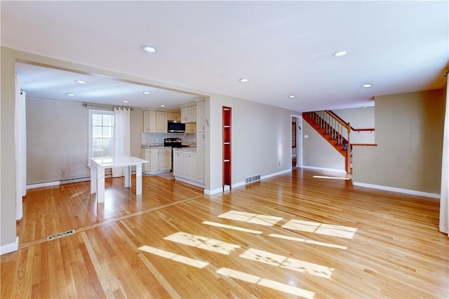 23 Sarah St, Providence, RI 02906 - unfurnished living room featuring baseboards, stairs, light wood-style floors, and recessed lighting