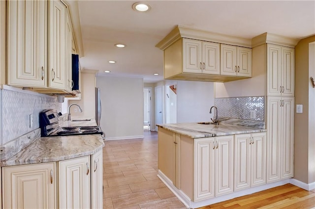 23 Sarah St, Providence, RI 02906 - kitchen with a sink, cream cabinetry, backsplash, baseboards, and recessed lighting