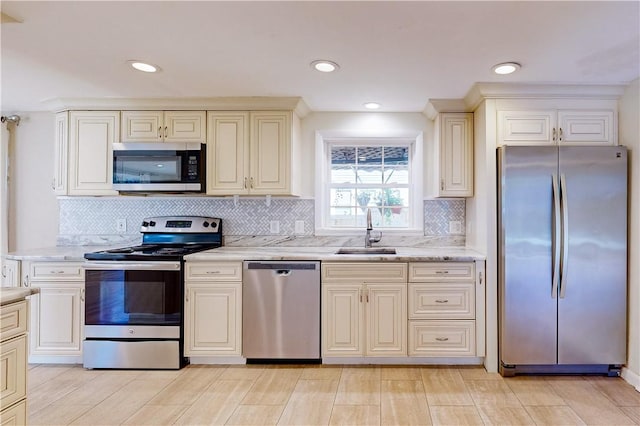 23 Sarah St, Providence, RI 02906 - kitchen featuring stainless steel appliances, a sink, backsplash, light stone counters, and cream cabinets